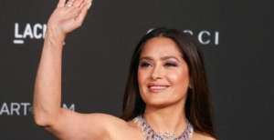 水晶皮卡丘Salma Hayek一袭紫色长裙高调亮相，站台上挥手打招呼亲和力强售价万